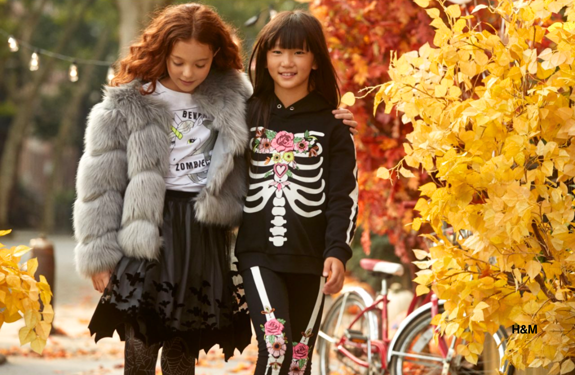 Two girls dressed for Halloween walking outside.