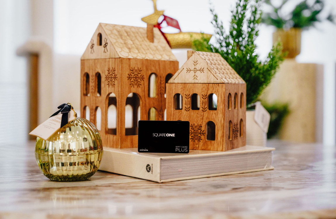 A Square One gift card on a living room table decorated with holiday decor.